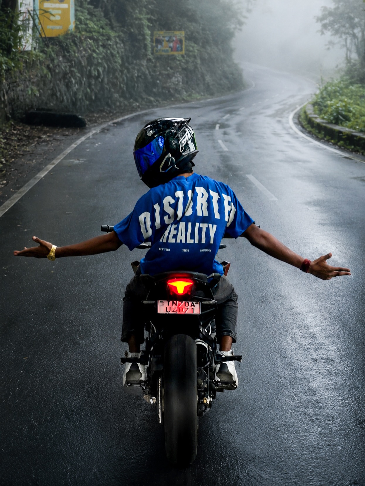 Sachin riding through a misty ghat road, arms wide open